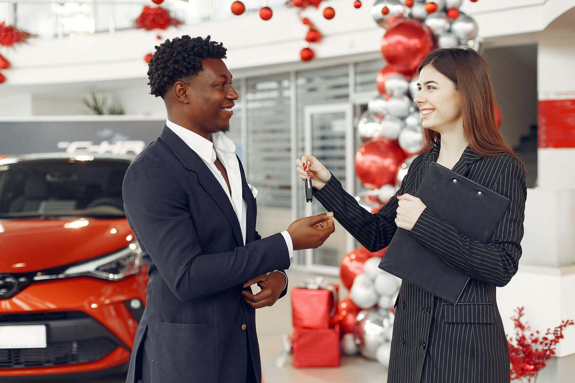 Professional luxury car salesman with a customer